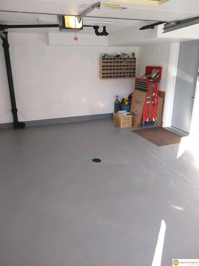 garage with concrete block wall and a garage door opener