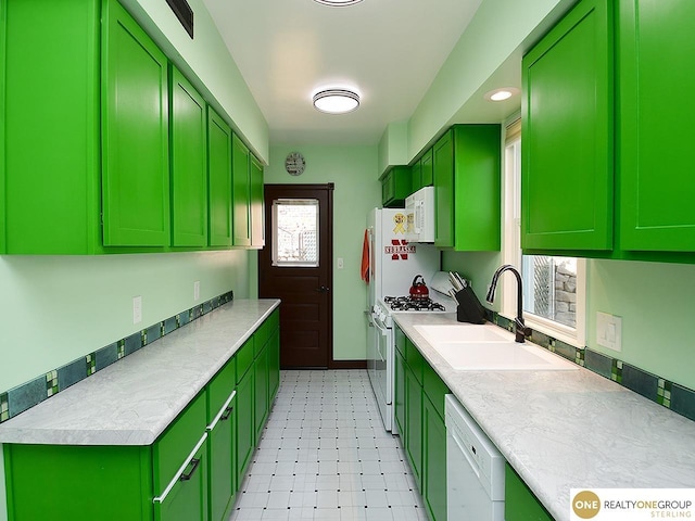 kitchen featuring green cabinetry, white appliances, light countertops, and a sink