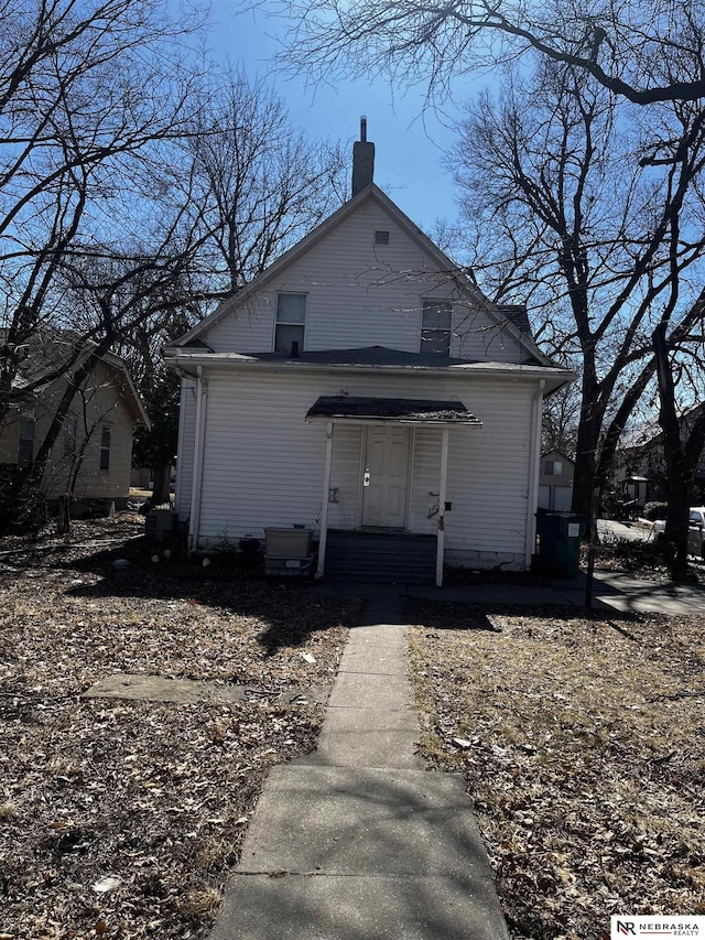 rear view of property featuring a chimney