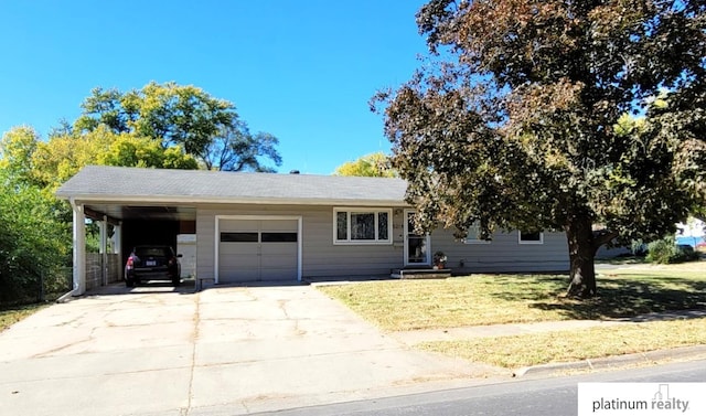 view of front facade featuring an attached carport, concrete driveway, a front yard, and an attached garage