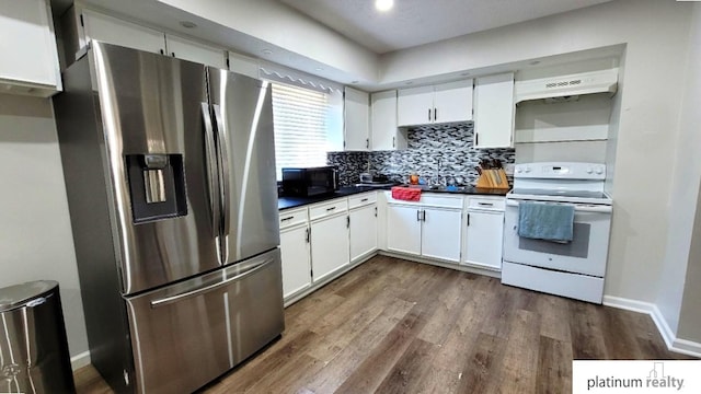 kitchen with white electric range oven, stainless steel refrigerator with ice dispenser, black microwave, under cabinet range hood, and dark countertops