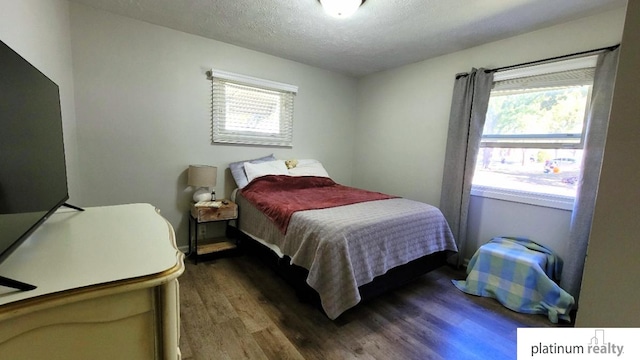 bedroom featuring wood finished floors and a textured ceiling