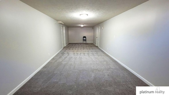 hallway featuring a textured ceiling, baseboards, and carpet floors