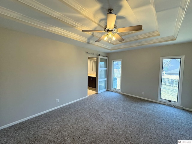 spare room with light colored carpet, baseboards, crown molding, and a tray ceiling