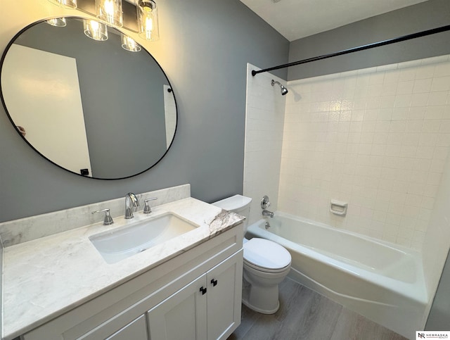 bathroom featuring toilet, shower / washtub combination, wood finished floors, and vanity