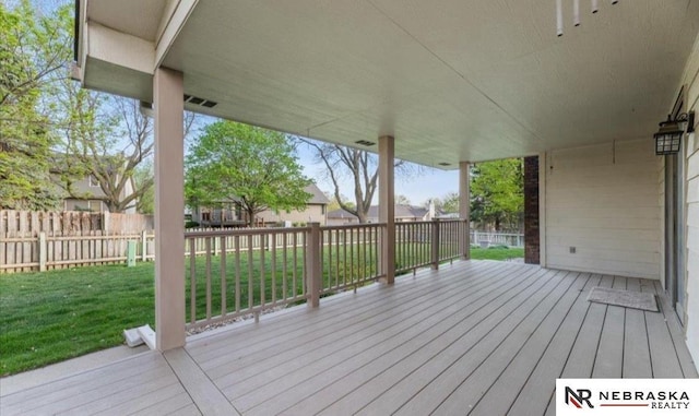 deck featuring a lawn and fence