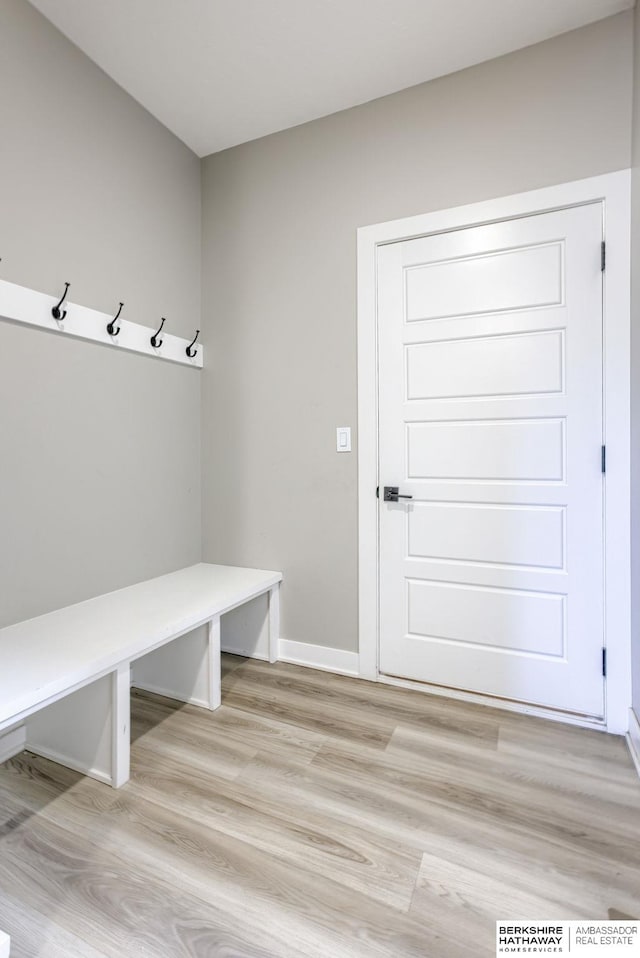 mudroom featuring light wood finished floors and baseboards