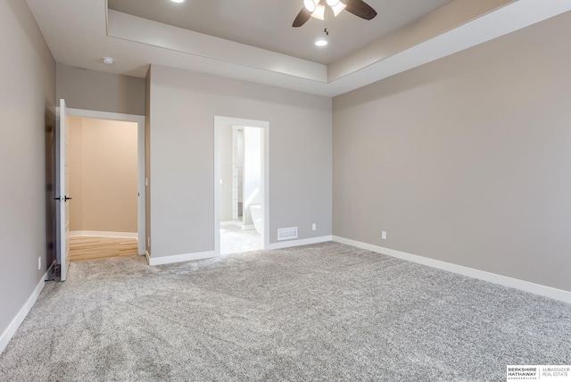 unfurnished bedroom with visible vents, baseboards, a raised ceiling, and carpet flooring