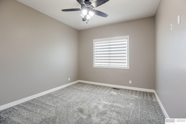 spare room with carpet flooring, visible vents, baseboards, and a ceiling fan