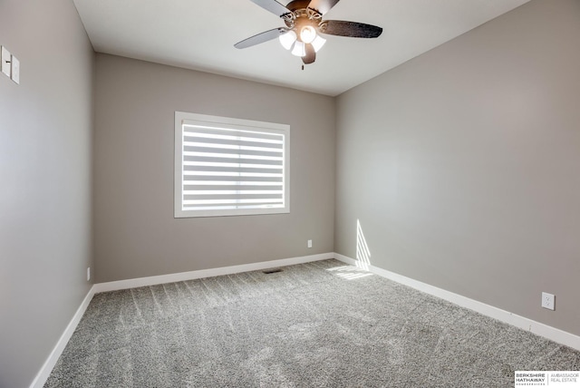 carpeted spare room featuring visible vents, baseboards, and ceiling fan