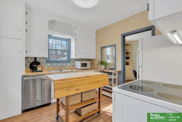 kitchen with white cabinets, white appliances, light countertops, and a sink