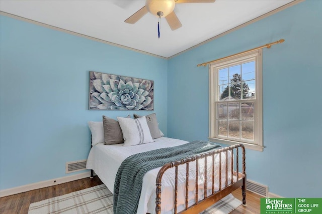 bedroom with visible vents, baseboards, and wood finished floors