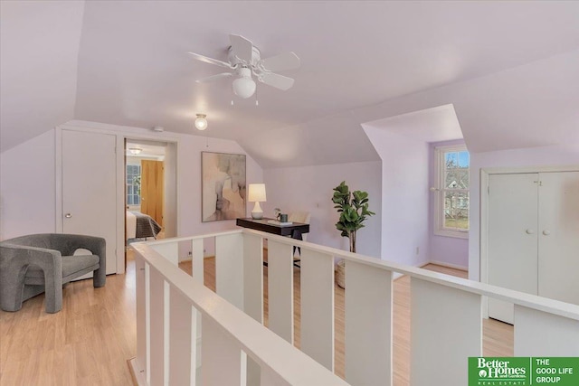 hall with light wood finished floors and lofted ceiling