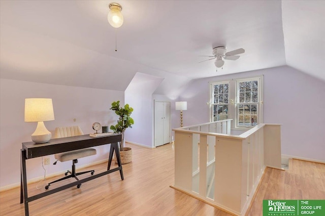 interior space featuring light wood finished floors, baseboards, ceiling fan, and vaulted ceiling