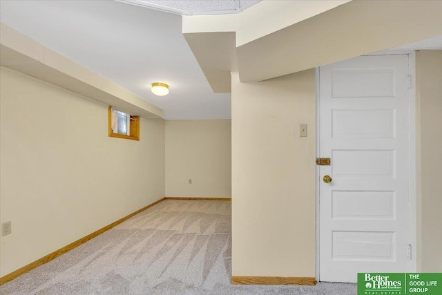 below grade area featuring carpet flooring and baseboards