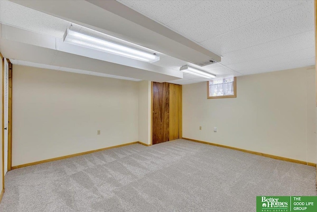 below grade area featuring baseboards, visible vents, and carpet floors