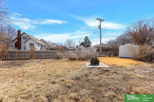 view of yard with fence private yard and a fire pit