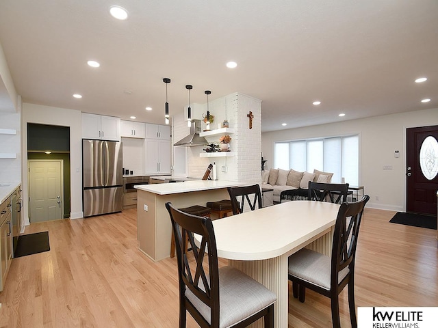 dining area featuring light wood finished floors, recessed lighting, and baseboards