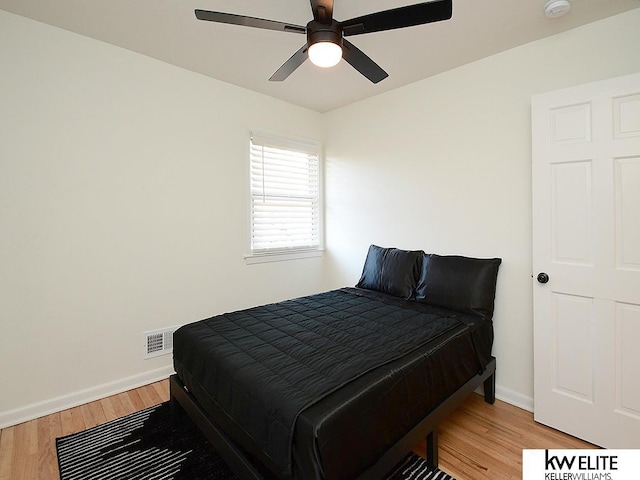 bedroom with visible vents, baseboards, and light wood finished floors