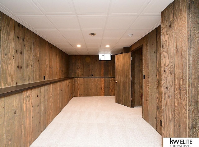 basement featuring recessed lighting, wood walls, and carpet flooring