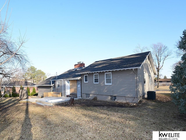 back of house with cooling unit, a chimney, and a yard