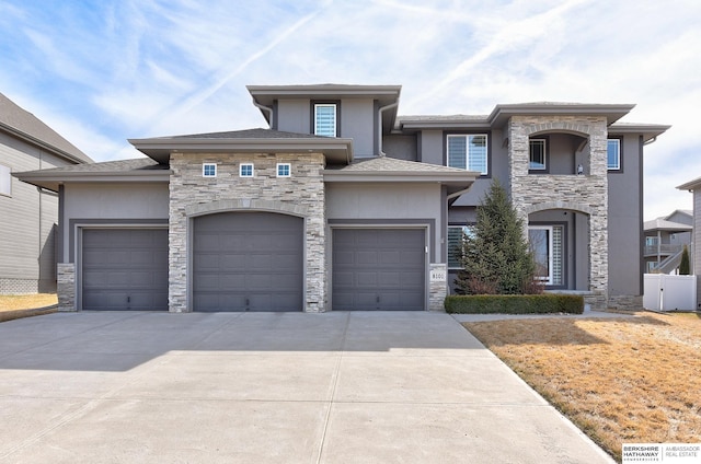 prairie-style house with stucco siding, stone siding, and a garage