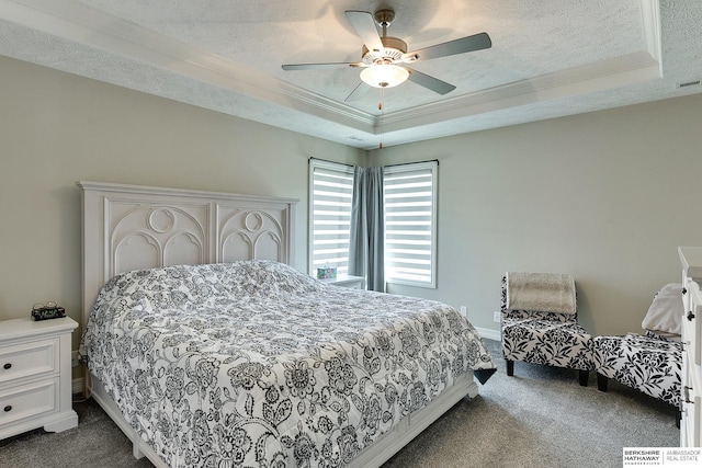 bedroom featuring crown molding, ceiling fan, a tray ceiling, a textured ceiling, and dark colored carpet