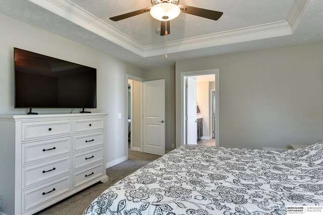 carpeted bedroom featuring a textured ceiling, crown molding, and a tray ceiling