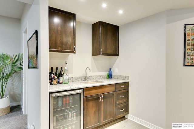 bar featuring baseboards, visible vents, wet bar, a sink, and wine cooler