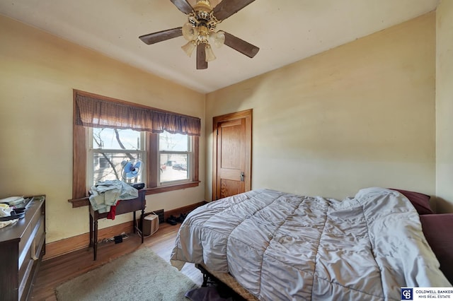 bedroom featuring baseboards, ceiling fan, and wood finished floors