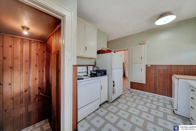 kitchen with a wainscoted wall, white cabinetry, white appliances, wooden walls, and light floors