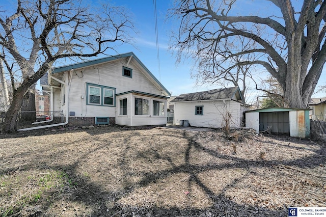 back of house featuring an outbuilding, a shed, and fence