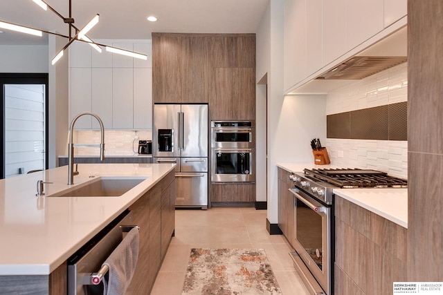 kitchen featuring tasteful backsplash, light tile patterned floors, stainless steel appliances, modern cabinets, and a sink