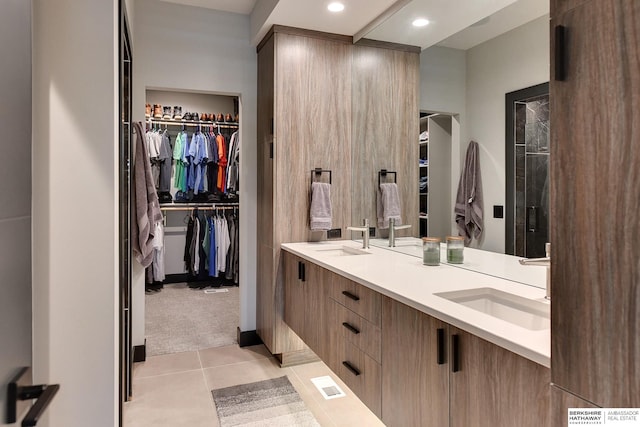 full bath featuring a sink, a spacious closet, tile patterned floors, and double vanity