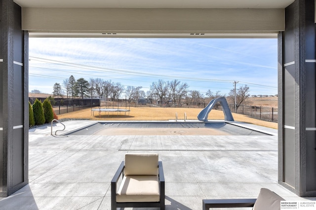 view of patio featuring a trampoline and fence