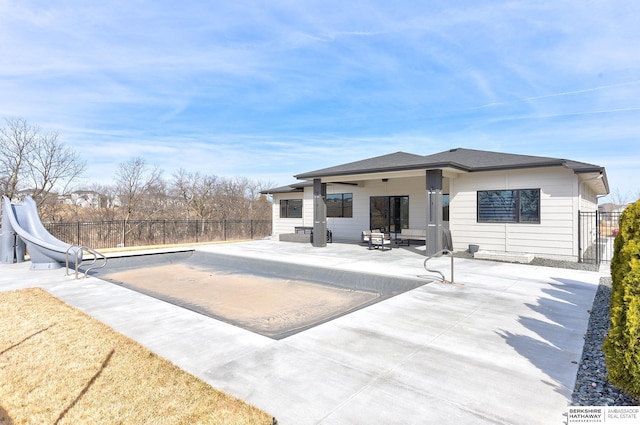 rear view of property featuring a patio and fence