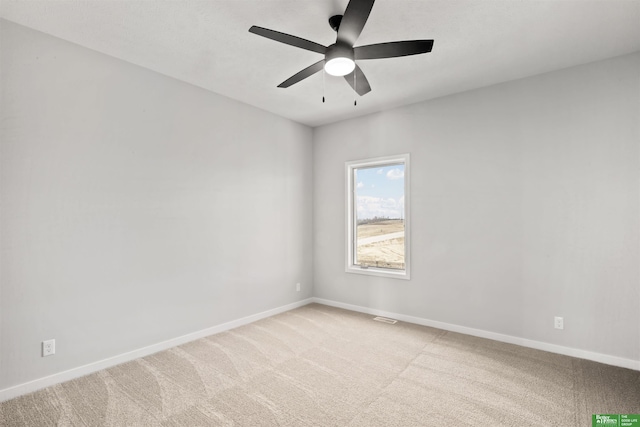 carpeted empty room featuring visible vents, baseboards, and ceiling fan