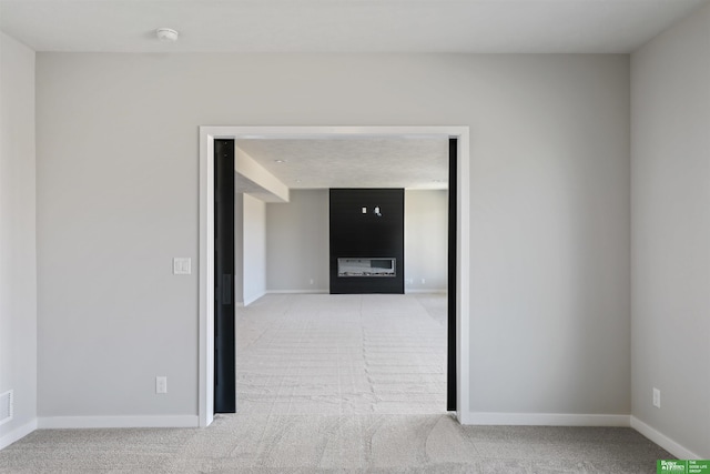 carpeted empty room featuring baseboards