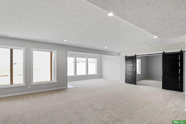 interior space with baseboards, carpet, and a barn door