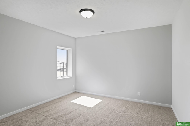 empty room featuring visible vents, baseboards, and carpet flooring