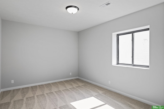 carpeted spare room with visible vents and baseboards