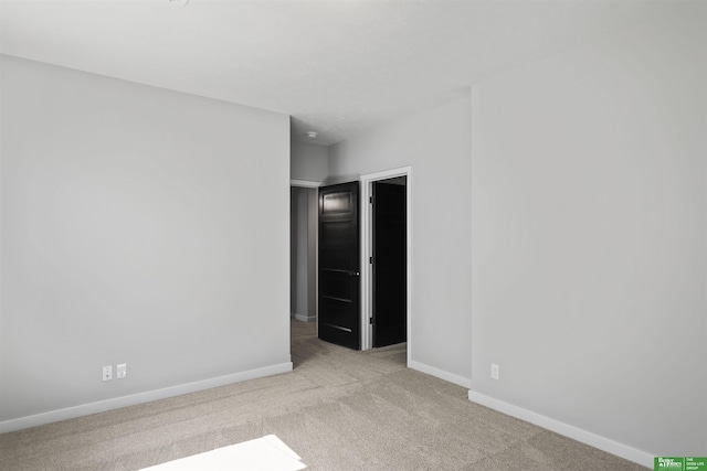 carpeted spare room featuring baseboards