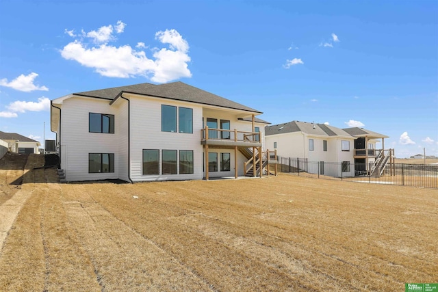 rear view of property with stairway, a yard, and a fenced backyard