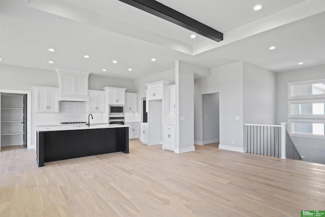 kitchen featuring white cabinetry, light countertops, light wood-style floors, and stainless steel appliances