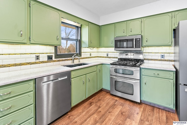 kitchen featuring a sink, stainless steel appliances, dark wood-style floors, and light countertops