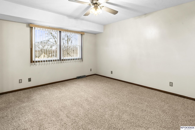 carpeted empty room with visible vents, baseboards, and a ceiling fan