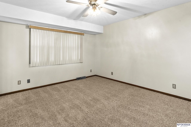 carpeted spare room featuring baseboards, visible vents, and ceiling fan