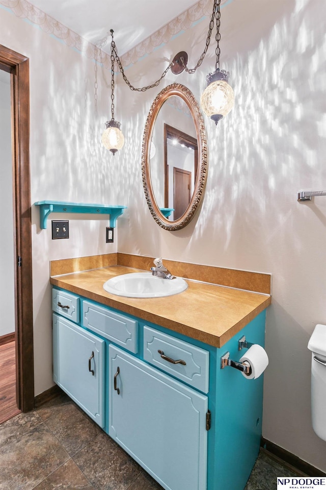 half bath featuring baseboards, toilet, and vanity