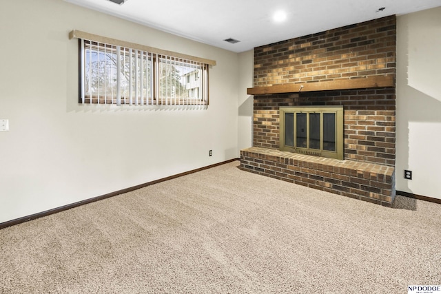 unfurnished living room with visible vents, baseboards, a fireplace, and carpet flooring