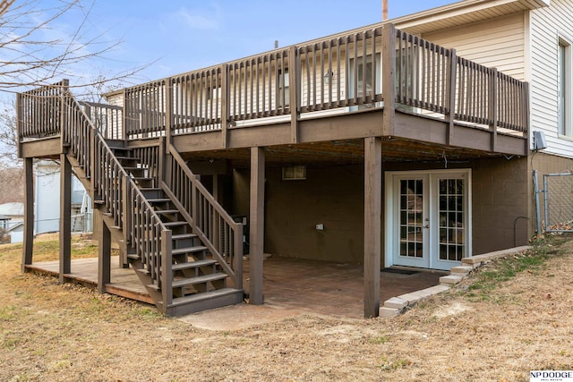 back of property featuring french doors, concrete block siding, a deck, and stairs